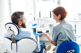 patient and dentist smiling while reviewing xray