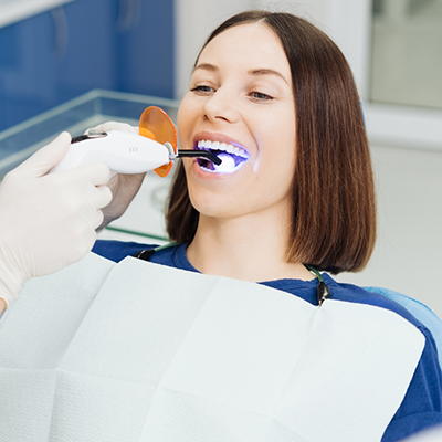 Female dental patient receiving cosmetic dental bonding