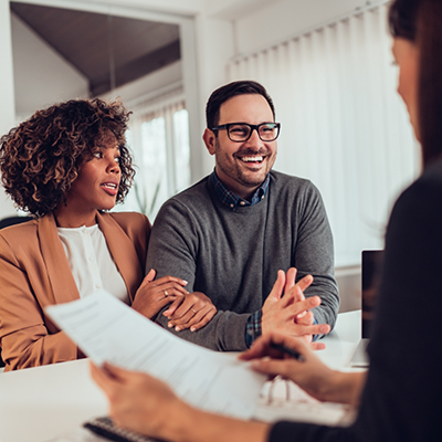 Woman and man with glasses talking to dental team member