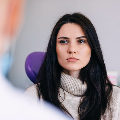 Woman in sweater sitting in dental chair