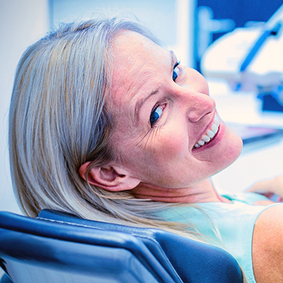 Senior woman in dental chair looking back and smiling