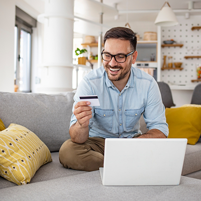 Man sitting at laptop looking at credit card