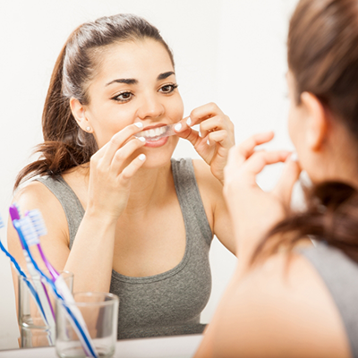 Woman putting in tray for take home teeth whitening in River Ridge
