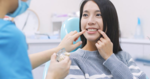 Patient eagerly pointing out her teeth to her dentist